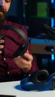 Vertical Tech expert testing headphones, review them for online streaming platforms. Professional audiophile hosts internet show, using sound mixer to check audio device sound sensitivity, camera A video