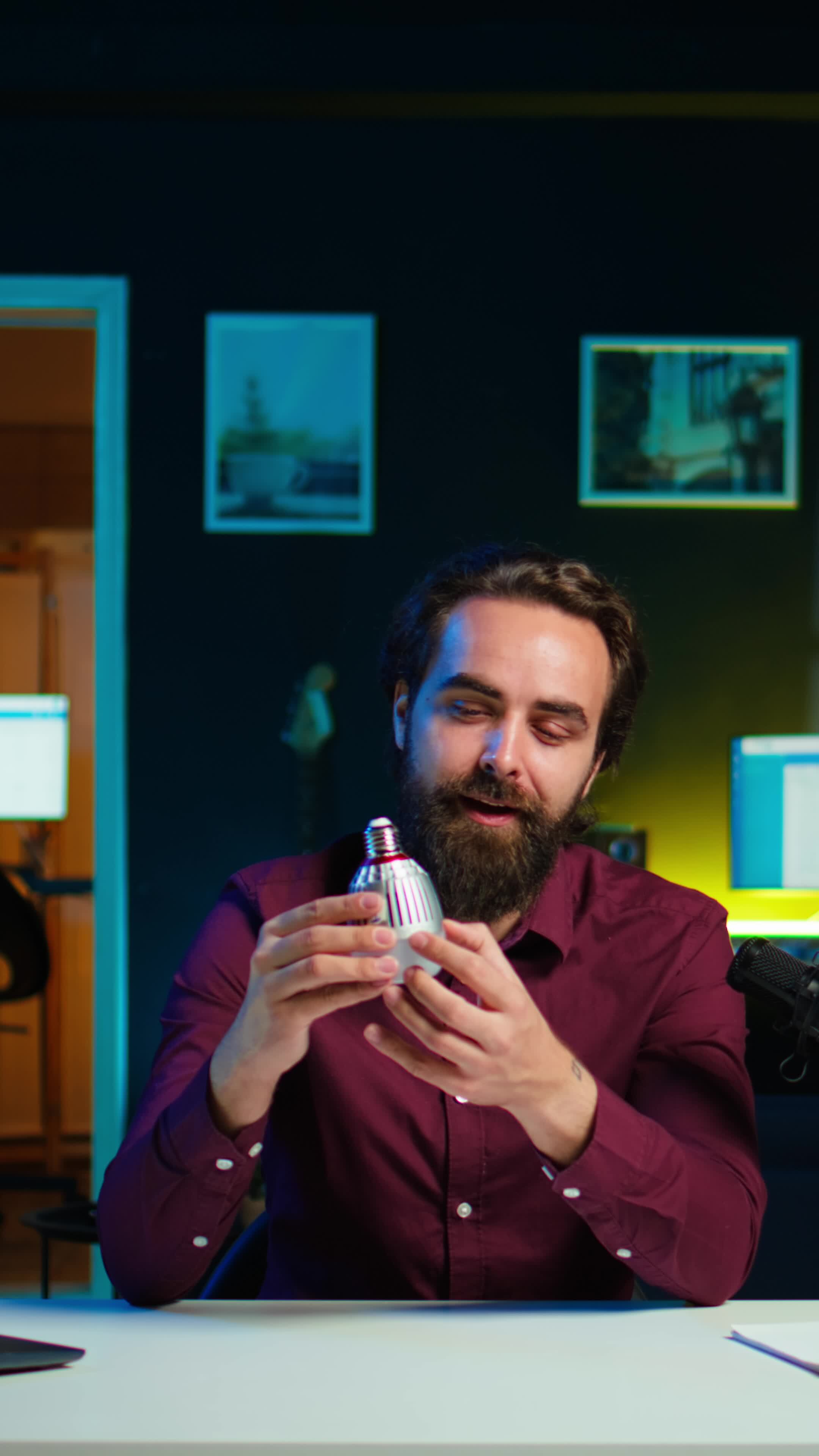 Vertical Tech guru in dimly lit apartment studio filming smart light