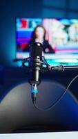 Vertical Streaming microphone equipment used to record discussions for internet livestreaming channel, close up. Jib down shot of sound capturing and recording gear in empty living room with neon lights video