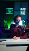Vertical Tech guru filming technology review of mini led lights, offering feedback, close up shot. Friendly online star showing filming equipment to subscribers, talking in mic, camera B video