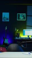 Vertical Playful internet star using microphone to shoot , doing frantic gesturing. Energetic content creator hiding under desk while filming vlog with professional mic in home studio, camera B video