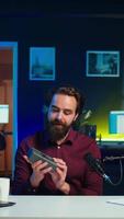 Vertical Technology specialist filming technology review of V mount battery, unpacking it and presenting specifications to viewers. Internet star showcasing charging device to subscribers video