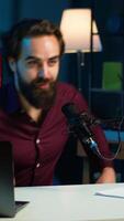 Vertical Smiling media star arriving in studio, using professional recording equipment to film vlog channel intro for online streaming platforms. Cheerful man starting stream, greeting viewers, camera A video