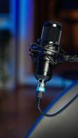 Vertical Podcast microphone used to record discussions for online livestreaming channel, close up. Streaming sound capturing and recording technology in empty living room with neon lights video