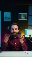 Vertical Tech expert presenting tablet in entry level low budget price range to interested viewers, filming in studio. Viral content creator reviewing digital device in front of internet audience, camera B video