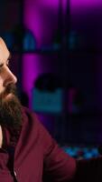 vertical fechar acima do conteúdo O Criador usando microfone dentro estúdio para Faz asmr , discutindo com espectadores usando calmante voz. homem usando profissional microfone para registro podcast com fresco som, Câmera uma video
