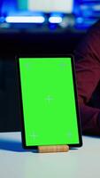 Vertical Happy influencer in studio filming chroma key tablet review for tech enthusiasts. Joyful media star hosts technology internet show, unboxing isolated screen digital portable device, camera A close up video