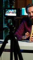Vertical Online show host reading and recommending best reviewed books of the year. Content creator in studio doing novel summaries for interested readers, speaking in professional mic, camera A video