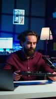Vertical Content creator filming technology review of newly released DJ controller, unboxing it, excited to look at specifications. Influencer showcasing sound mixer device to viewers, camera B video