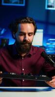 Vertical Content creator filming technology review of newly released DJ controller, unboxing it, excited to look at specifications. Influencer showcasing sound mixer device to viewers, camera A video