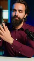 Vertical Portable V mount battery presented by knowledgeable tech professional to audience in studio. Lithium li ion charging device held by content creator doing presentation, camera A video