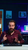 Vertical Artist filming DJ mixing tutorial, showing examples of sampling on sound controller to viewers. Viral online star showing modern musical equipment to subscribers in home studio, camera B video