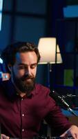 Vertical Man filming technology review, recommending newly launched DJ controller. Influencer advocating for high quality sound mixer device in front of followers after testing it, camera A video