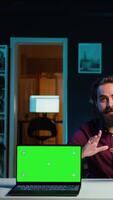 Vertical Entertainer presents chroma key laptop from brand sponsoring , analyzing features. Content creator reviewing green screen notebook for technology enthusiasts, inspecting materials, camera B video