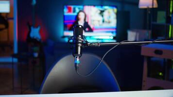 Streaming microphone equipment used to record discussions for internet livestreaming channel, close up. Jib down shot of sound capturing and recording gear in empty living room with neon lights video