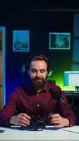 Vertical Tech expert testing headphones, review them for online streaming platforms. Professional audiophile hosts internet show, using sound mixer to check audio device sound sensitivity, camera B video