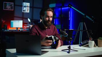foco em Smartphone em anexo para tripé usava de conectados Estrela dentro embaçado fundo discutindo com espectadores. Móvel telefone usava de influenciador para registro social meios de comunicação , Câmera b fechar acima video