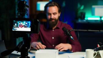 Tech guru assessing smartphone performance, feeling happy with high quality components used. Content creator shoots mobile phone review for online channel, recommending it, camera A video