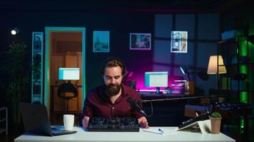 Tech guru filming technology review of newly released DJ controller, unboxing it and presenting specifications to audience. Influencer showing sound mixer equipment to followers, camera B video