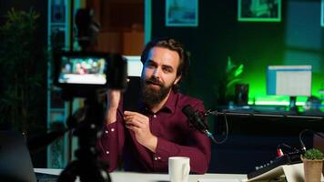 Man presents mobile phone from brand sponsoring , closely analyzing features. Content creator reviewing smartphone for technology enthusiasts, inspecting camera, camera A video