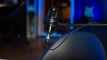 Podcast microphone used to record discussions for online livestreaming channel, close up. Streaming sound capturing and recording technology in empty living room with neon lights video