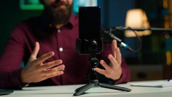 asmr conteúdo O Criador usando qualidade microfone e celular em tripé para Faz anti estresse , usando sussurrando voz, fechar acima. homem usando profissional microfone para induzir sonolência para espectadores, Câmera uma video