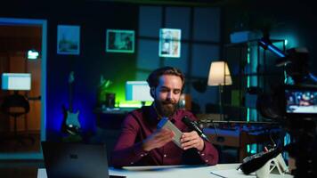 man håller på med teknologi recension av trådlös bärbar högtalare för internet vlogging kanal. musik spelar enhet hölls förbi innehåll skapare som visar den till hans prenumeranter, kamera b video