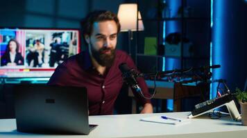 Smiling media star arriving in studio, using professional recording equipment to film vlog channel intro for online streaming platforms. Cheerful man starting stream, greeting viewers, camera A video