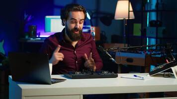 Artist filming DJ mixing tutorial, showing examples of sampling on sound controller to viewers. Viral online star showing modern musical equipment to subscribers in home studio, camera A video