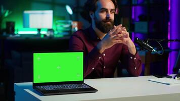 Tech guru in studio filming tech tutorial on how to do maintenance on chroma key laptop. Internet show host teaching viewers how to open and repair damaged green screen notebook, camera A video