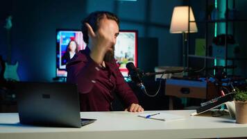 Expressive media star using microphone to shoot , doing frantic gesturing. Energetic influencer making hectic hand movements while filming vlog with professional mic in home studio, camera A video