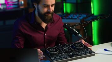 Tech guru filming technology review of newly released DJ controller, unboxing it and presenting specifications to audience. Influencer showing sound mixer equipment to followers, camera A video