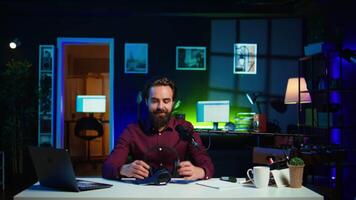 Tech expert testing headphones, review them for online streaming platforms. Professional audiophile hosts internet show, using sound mixer to check audio device sound sensitivity, camera B video