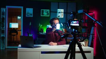 Tech guru filming technology review of mini led lights, offering feedback, close up shot. Friendly online star showing filming equipment to subscribers, talking in mic, camera B video