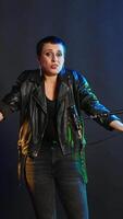 Vertical Heavy metal performer acting uncertain and shrugging in doubt, being clueless and uncertain about an answer. Confused doubtful woman artist having no idea about something. Camera B. video