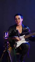 Vertical Voice training instructor teaching people to play the guitar on online lesson live tutorial, doing a practice session during virtual class. Superstar vocal coach does singing lessons. Camera B. video