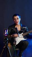 Vertical Social media artist live streaming a song for her music vlog, live event vocal performance online on internet. Content creator doing a broadcast for fan engagement, online concert. Camera B. video