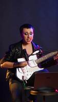 Vertical Pleased punk rock artist rehearsing for her live performance, focusing on vocal training and warm up. Edgy iconic woman enjoying singing practice with alternative music. Camera B. video
