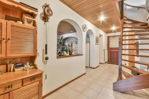 A hallway with wooden cabinets and a staircase photo
