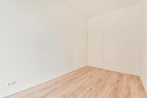 An empty room with wooden floors and white walls photo