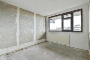An empty room with a window and a radiator photo