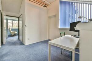 A room with a desk and a window photo