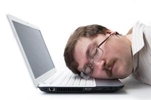 man sleeping on a notebook keyboard at the workplace photo