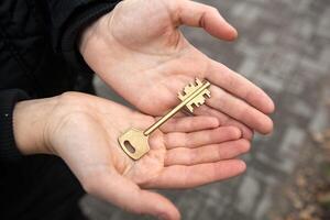 hand holds the key to an apartment in a new building photo