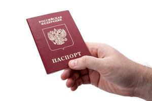 Russian passport in the hand of a man on a white background as identification photo
