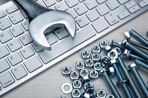 screws fastening materials and pc keyboard and a wrench photo