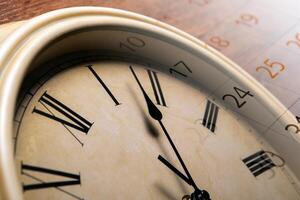 clock face with sheet of a calendar with the number of days photo
