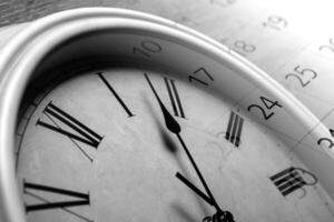 face clock and sheet of a calendar with the number of days photo