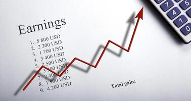 table with earnings with digits, calculator and diagram photo