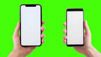 Two hands holding up two smartphones with blank screens on a green screen video